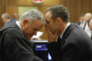 Oscar Pistorius praat met sy prokureur, adv. Barry Roux, op 4 Maart in die hof. Foto: SAPA