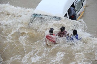 Passasiers klou aan 'n taxi terwyl 'n vloedgolf hul tref in New Canadaweg in Pennyville, Soweto op 5 Maart 2014 | Foto: Michel Bega, Citizen