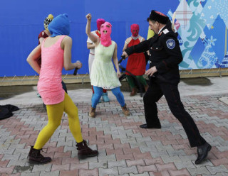 Foto: Lede van Pussy Riot loop onder die rottang van ‘n Kossak-veiligheidsbeamte deur tydens die Olimpiese Winterspele in Februarie in Rusland. Foto: AP