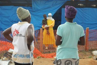 Vrywilligers van Dokters Sonder Grense by die Foya-sentrum in noordelike Liberië help Helena (regs) om met haar seuntjie Moses, wat met die ebola-virus besmet is, te gesels #decidetodonate http://bit.ly/dcd2dnt