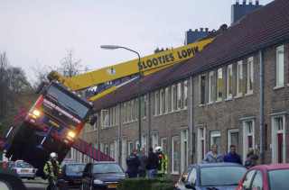 Die hyskraan bo-op die woonstelblok se dak in Nederland, 13 Desember 2014 Foto: ap, Algemeen Dagblad