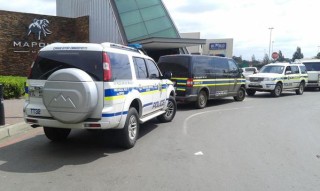 Polisievoertuie staan voor die Maponya Mall.  Foto: @King_Names op Twitter.