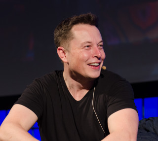 Elon Musk by 'n beraad in 2013 Foto: Heisenberg Media - Flickr: Elon Musk - The Summit 2013 via Wikimedia Commons