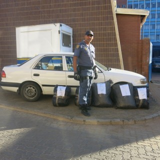 Konstabel Neil Jacobs van die Kimberley-polisie by die dagga wat gekonfiskeer is en die voertuig wat gebruik is Foto: SAPD, verskaf