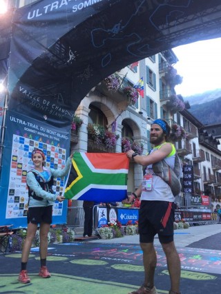 Alana Doyle en Armand du Plessis hou die Suid-Afrikaanse vlag omhoog by die eindstreep van UTMB 2015 Foto: Nic Bornman (foto verskaf)