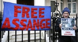 'n Betoger met 'n banier buite die Ecuadoriaanse ambassade in Londen waar Julian Assange bly (4 Februarie 2016) Foto: AP Photo/Kirsty Wigglesworth