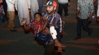 'n Man dra 'n beseerde kind weg ná die aanval Foto: CNN