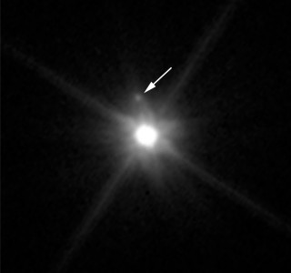 Die dwergplaneet Makemake se maan (Foto: NASA, ESA en A. Parker en M. Buie (SwRI))