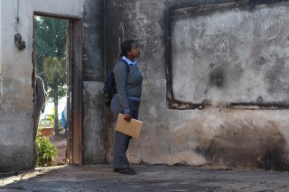 Mpho Rambau, 'n Graad 12-leerder, by haar skool in Vuwani, Limpopo wat deur betogers aan die brand gesteek is. Foto: ANA