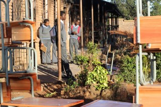 Skoliere staan en kyk hoe meubels afgelaai word by een van die skole in Vuwani, Limpopo wat erg deur betogers beskadig is. Foto: ANA