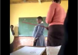 'n Skermskoot uit die video van 'n voorval by die Prince Tokotoko High School in KwaNongoma, KwaZulu-Natal waar 'n onderwyseres na bewering minstens vyf meisies met ŉ stok op die rug slaan.