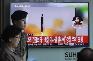 Suid-Koreane loop verby ŉ televisie met ŉ beeld van Noord-Korea se ballistiese missiel wat vandag in Noord-Korea se Rodong Sinmun-koerant geplaas is. Die skrif op die skerm lees: “Die VN-veiligheidsraad het ŉ noodvergadering gehou oor Noord-Korea se lansering van twee ballistiese missiele.” Noord-Korea se leier, Kim Jong Un, het vandag die sukses van ŉ kragtige nuwe missieltoets aangekondig, wat volgens staatsmedia een van die wapens meer as 1 400 km aangedryf het en blykbaar Amerikaanse magte in die streek sal kan aanval. Foto: Ahn Young-joon/AP via wire.africannewsagency.com