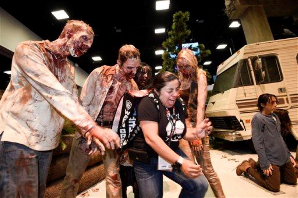 Martha Guzman gil tydens ’n fotosessie met zombies van die “Walking Dead”-stalletjie, by Comic-Con International se voorskou-aand in San Diego, Kalifornië. Foto: Denis Poroy/Invision/AP/wire.africannewsagency.com