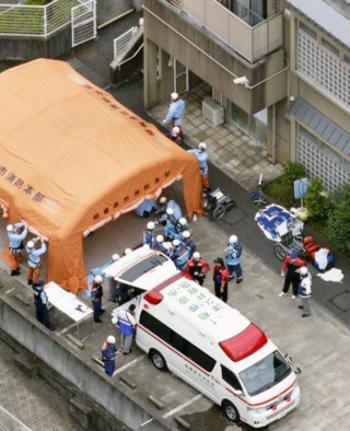Ambulansdienste en brandweermanne buite ŉ sorgsentrum vir gestremdes in die stad Sagamihara in Japan ná ŉ mesaanval Dinsdagoggend in die sentrum. Die dodetal staan op 19 en tientalle is beseer. Foto: Kyodo News via AP/ wire.africannewsagency.com