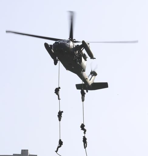 Suid-Koreaanse soldate hang uit ŉ helikopter tydens ŉ teen-terrorisme oefening naby die Jamsil Olimpiese stadion in Seoul. Die oefening is ter voorbereiding vir enige terroriste-aanvalle. Foto: AP Photo/Lee Jin-man