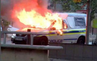 'n Polisievoertuig is Dinsdag in Braamfontein aan die brand gesteek. Foto: Twitter