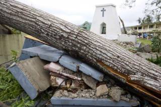 ŉ Grafsteen in Les Cayes in Haiti is in stukke gebreek nadat ŉ boom, wat deur Orkaan Matthew ontwortel is, daarop geval het (Donderdag, 6 Oktober 2016). Foto: AP/Dieu Nalio Chery