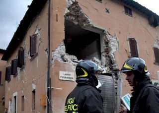 'n Brandbestryder by een van die geboue in Visso wat beskadig is. Foto: Pietro Crocchioni/ANSA via AP