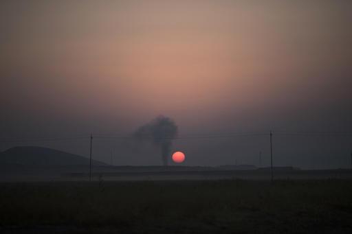 Die son kom op tussen die rookwolke ná ŉ lugaanval in Bashiqa, wes van Mosoel, in Irak. Foto: AP Photo/Felipe Dana
