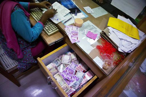 ŉ Bankklerk in Indië tel note waarvan die gebruik gestaak is in Gauhati in Indië. Foto: AP/ Anupam Nath