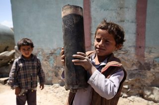 'n Seun hou 'n stuk van 'n kanonkoeël vas in Yemen se hoofstad. Foto: Unicef/Mohamed Hamoud