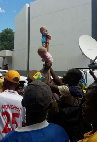 ANC-ondersteuners het twee poppe wat aan 'n stok vasgebind is voor die hof rondgeswaai. Foto: Landi Malan
