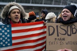 Betogers buite John F Kennedy-lughawe in New York nadat twee Irakese reisigers verbied is om die VSA te betree (28 Januarie 2017) Foto: AP Photo/Craig Ruttle