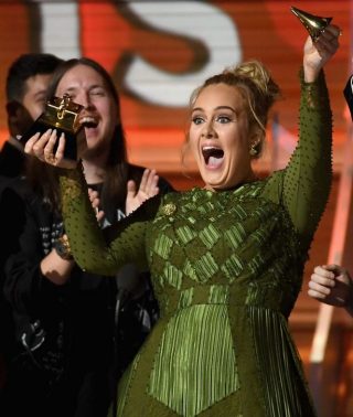 Adele breek die beeldjie in die helfte om die toekenning met Beyoncé te deel (Foto: Grammys/Getty Images)