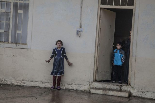Twee kinders staan buite terwyl spesiale magte van Irak huise in die omgewing deursoek vir lede van Isis (Foto: Laurent Van der Stockt/Getty Reportage vir Le Monde)
