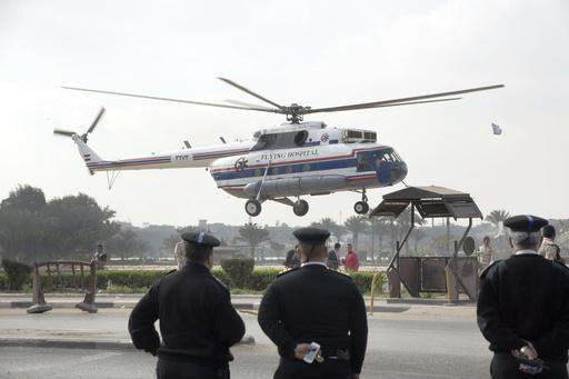 Polisiebeamptes kyk hoe ŉ ambulanshelikopter oudpres. Hosni Mubarak van Egipte van die Maadi militêre hospitaal na ŉ hof neem. Hy word weer verhoor op aanklagte dat hy medepligtig was in die moorde op betogers tydens die oproer in Egipte in 2011. (AP Photo/Amr Nabil)