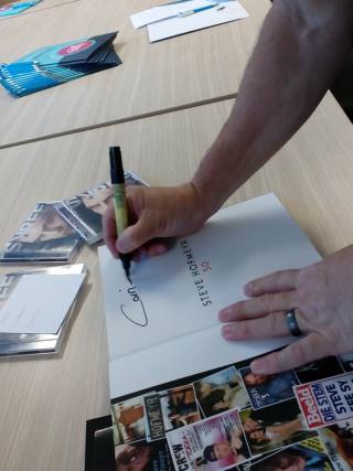 Steve teken sy aandenkingsboek vir een van die gaste. (Foto: Verskaf)